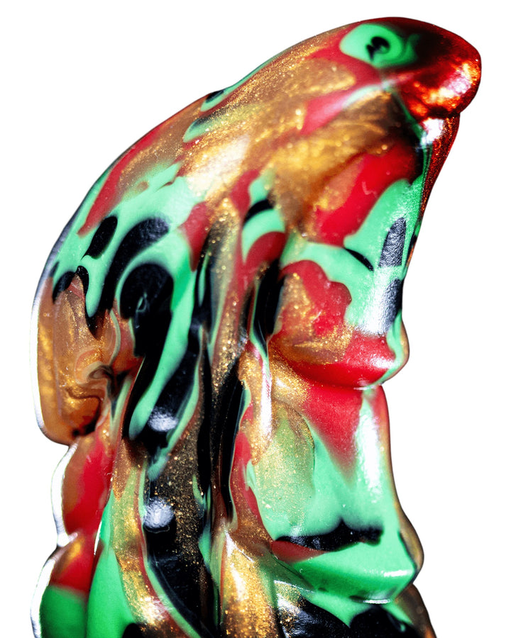 Close-up of Krampus’s rounded curved tip, showing elongated grooves and black, red, green and metallic gold marbling.