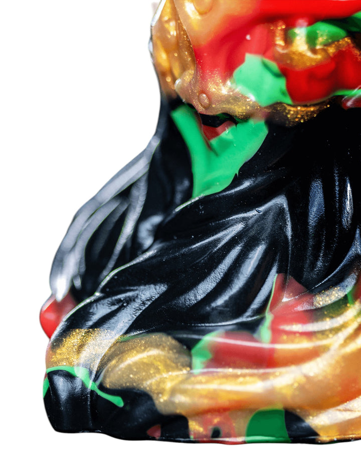 Close-up of Krampus’s flared base, showing flowing black ridges bordered by red, green and metallic gold marbling.