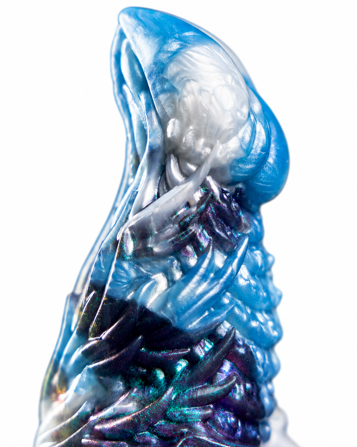 Close-up of Okami’s curved tip and sweeping ridges in pearlescent white, ice blue and iridescent purple on white.