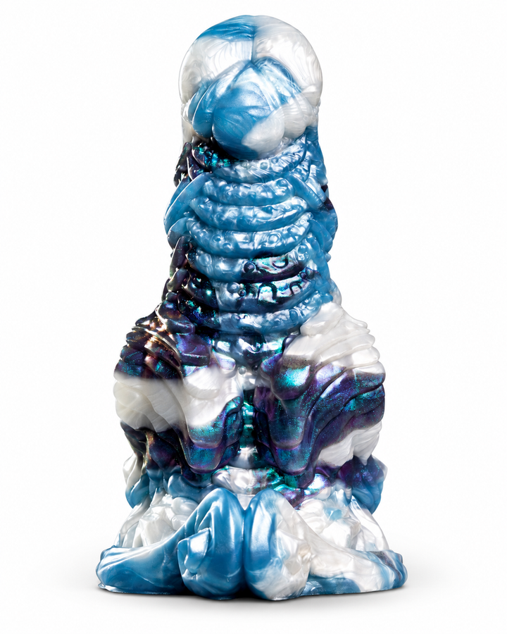 Okami silicone toy with sweeping raised ridges and a sculpted base, in shimmering blue, white and purple on white.