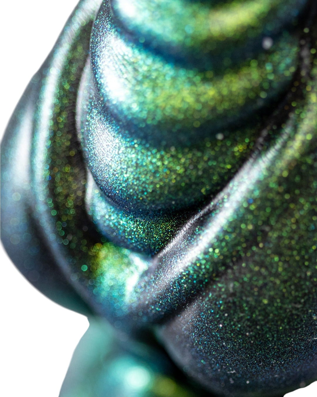 Close-up of rounded ribs and curved detailing on a Phreak silicone toy with an iridescent green and blue finish.